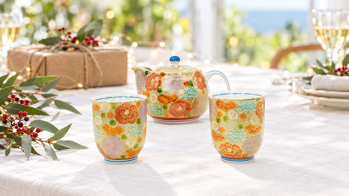 Kutani Gold Hanazume teapot set on a white Christmas lunch table with eucalyptus, red berries and a wrapped gift